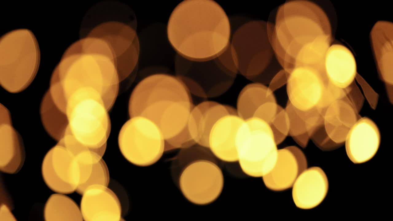 luz desenfocada parpadeando sobre un fondo negro oscuro, panorámica de derecha a izquierda