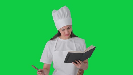 confundida india mujer chef profesional haciendo comida de libro pantalla verde