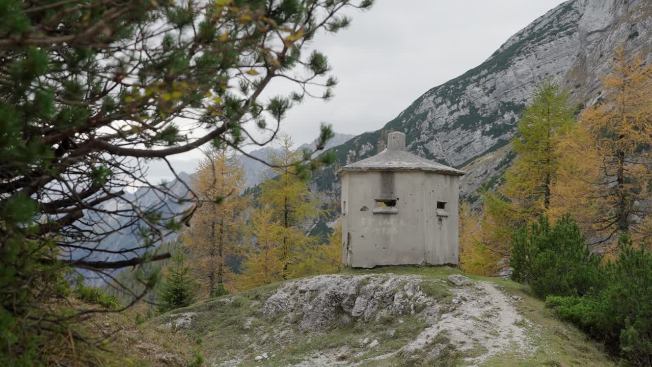Piccolo bunker in pietra su una collina in una foresta alpina al Passo di Vrsic, Slovenia, inquadratura statica media.