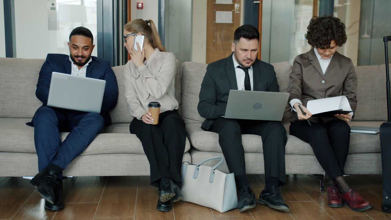 Professionisti aziendali in attesa nella hall dell'ufficio
