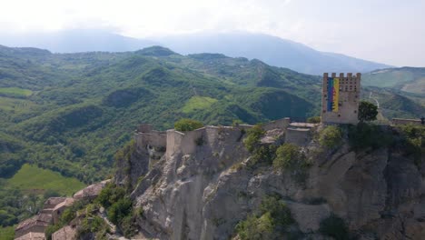 wide angle drone shot orbiting the medieval castle on a cliff called roccascalegna in the region of abruzzo in italy