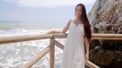 Young-Lady-in-White-Standing-at-Beach-Railings