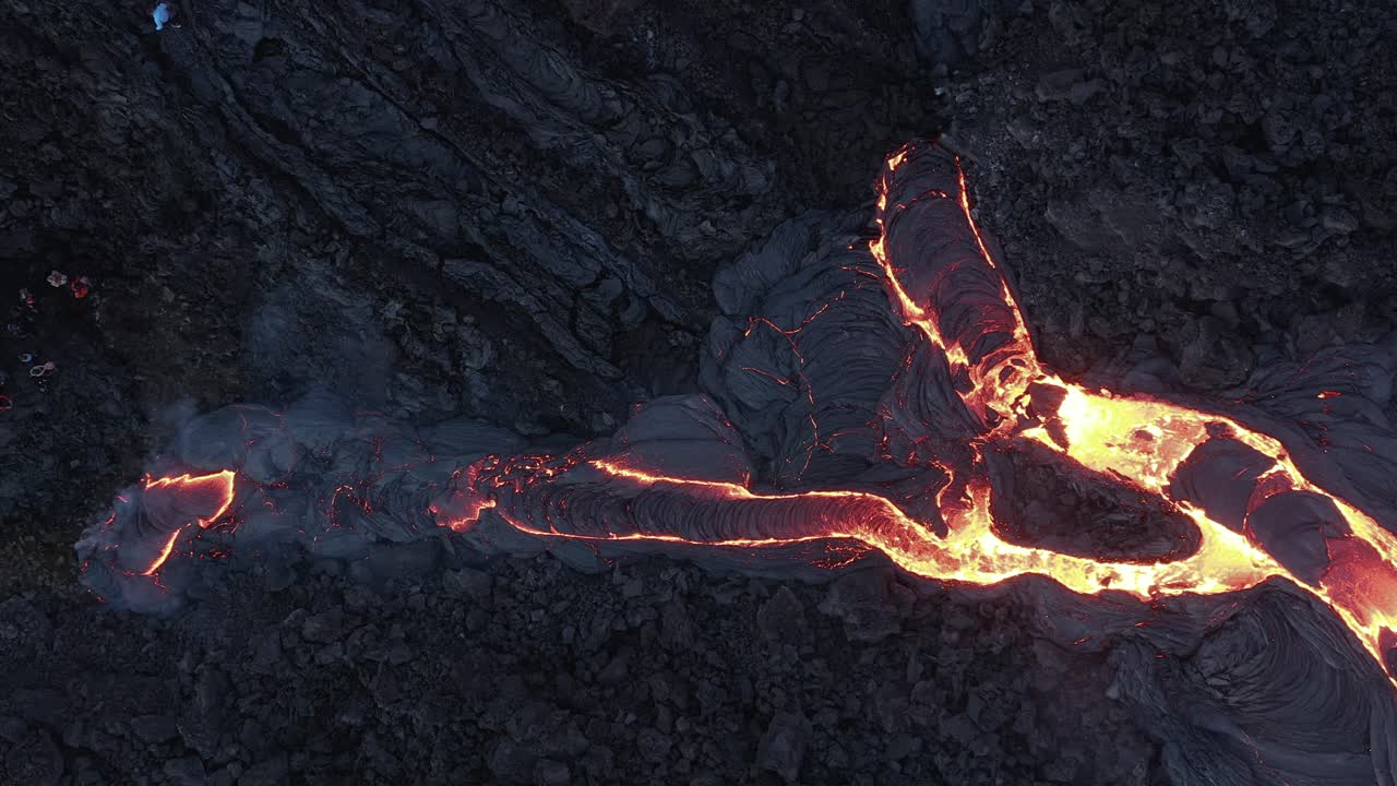 Flusso di lava viscosa che scorre sulla superficie scura della valle in Islanda