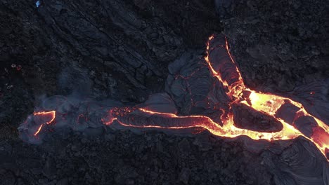 Stream-of-viscous-lava-flowing-on-dark-surface-of-valley-in-Iceland