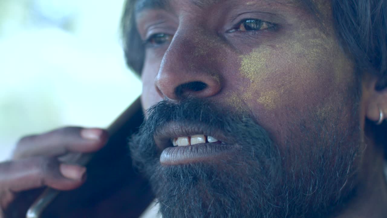 인도인 남자의 얼굴 클로즈업은 밝은 홀리 색으로 얼룩져 있습니다.