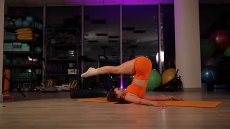 a woman shows flexibility and strength with impressive splits in yoga in a serene gym a woman demonstrates her flexibility by performing a split on a yoga mat transitioning to a meditative pose showcasing balance