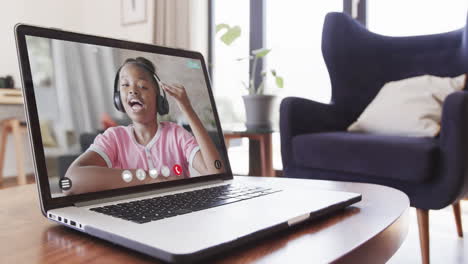 escolar afroamericana teniendo clase en una llamada de video portátil y hablando en cámara lenta