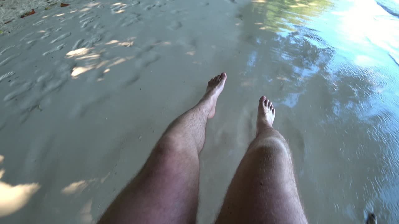 un tipo se balancea en un columpio en la playa.