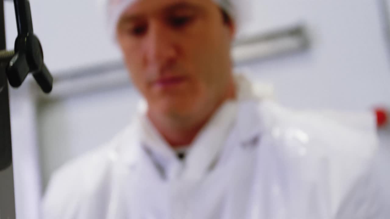 Butcher slicing red meat in bandsaw machine