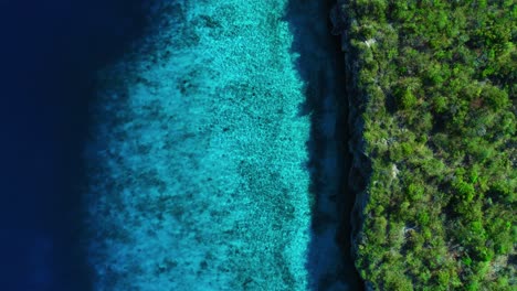 Top-view-of-light-ripples-reflecting-on-golden-sandy-below-turquoise-blue-water,-curacao-coastline