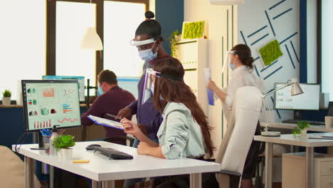 businesswoman with protective mask discussing with african colleague