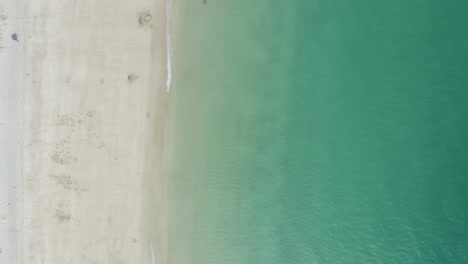 vertical shot of turquoise ocean with sandy seacoast at st ives bay in cornwall, united kingdom