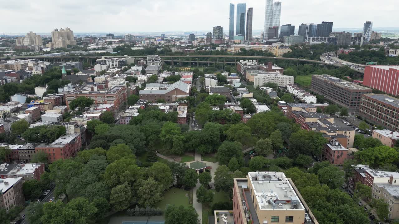 High-angle top-down view of a park in Jersey City featuring symmetrical paths, green spaces, and city layout, perfect for urban design, travel, lifestyle, or real estate visuals