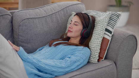 woman relaxing on a couch while listening to music