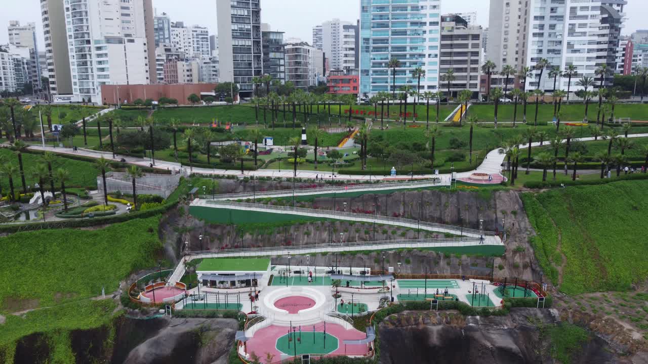 Aerial drone shot of a newly inaugurated public park in the district of Miraflores in Lima, Peru. Located in the edge of a cliff with green grass with a walkway leading down into it