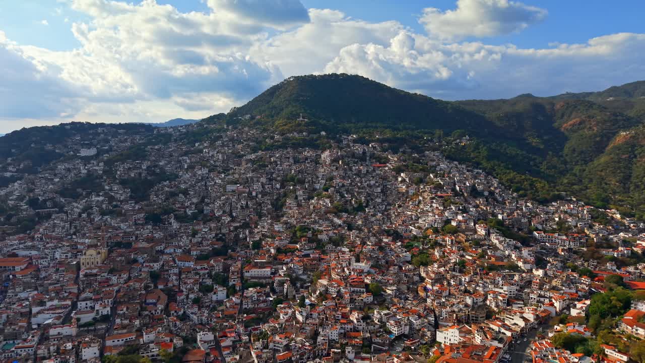 Ripresa aerea panoramica d'introduzione della magica città di Taxco a Guerrero, Messico, con architettura coloniale e il Monte Atachi sullo sfondo