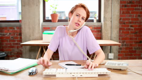 Casual-businesswoman-on-the-phone-at-her-desk