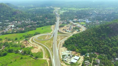 Expressway-drone-footage-transportation-industry-economy-development-roods-through-forest-transport-and-travel-highway-paddy-field-Sri-Lanka