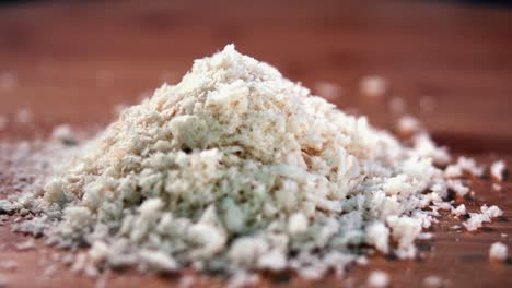 primer plano interior de migas de pan en un montón sobre una superficie de madera con más cayendo encima desde arriba