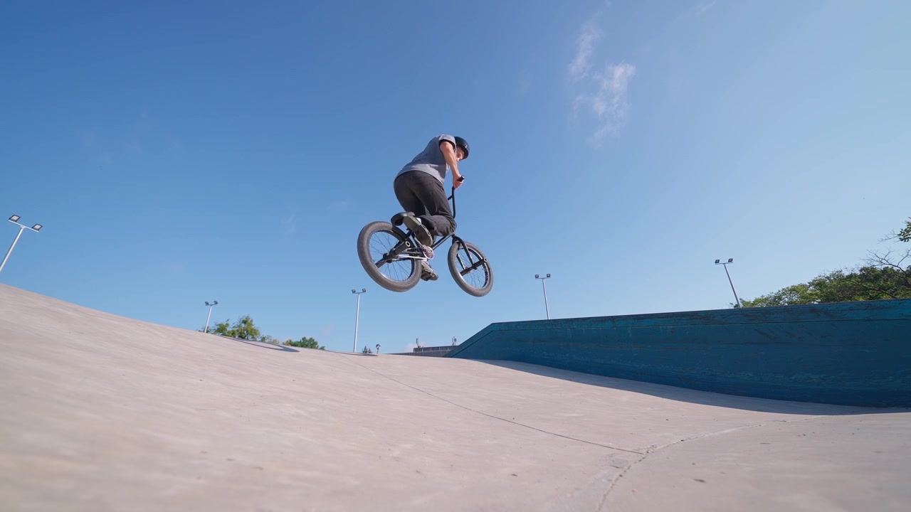 Ragazzo su una BMX che salta una rampa in uno skatepark