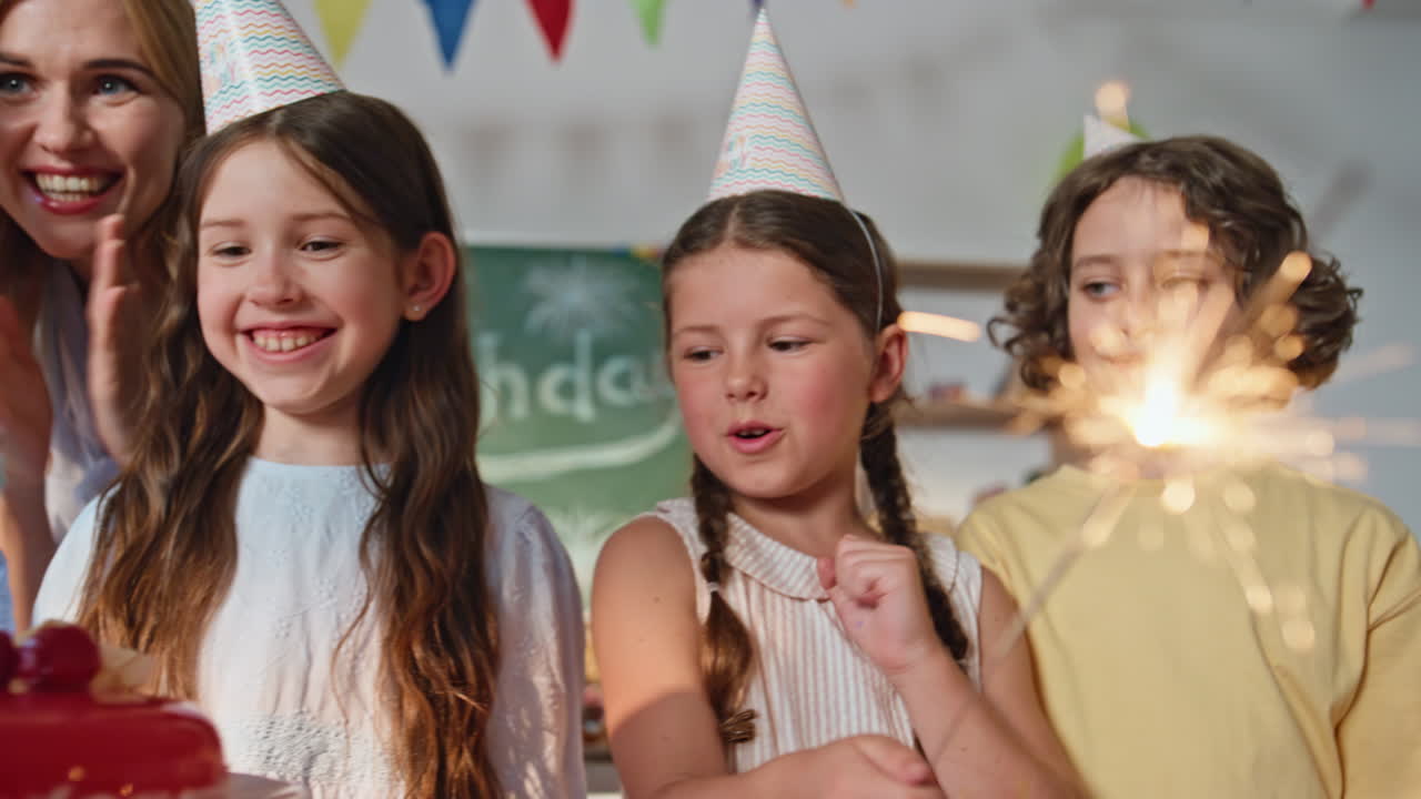 Children celebrating birthday party with happy teacher in classroom ...