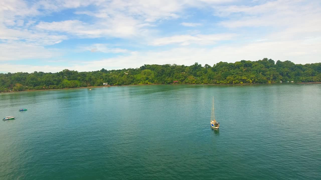 un velero monocasco anclado en una bahía de aguas tranquilas cerca de la costa de costa rica en la bahía de drake en un día de cielo azul nublado en el paraíso