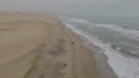 Car-Driving-on-Namibia's-Skeleton-Coast-Beach-Sand-Dunes,-Sandwich-Harbour,-Africa---Aerial