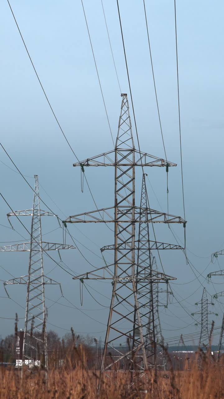 High Voltage Power Lines and Transmission Towers Against Overcast Sky