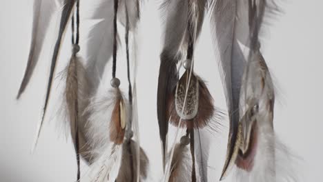 feathers from dreamcatcher slowly swaying indoors. locked off