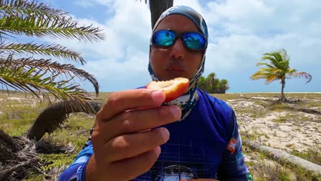 hombre comiendo dátiles frescos fruta recién tomada de la palmera, isla tropical cayo de agua