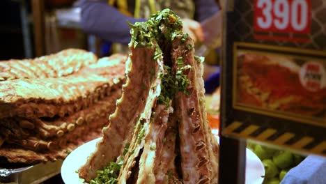 chef-chopping-pork-ribs-background-ribs-on-display-on-a-stall,-street-food-market