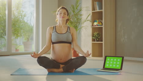 pregnant woman meditating with online yoga class