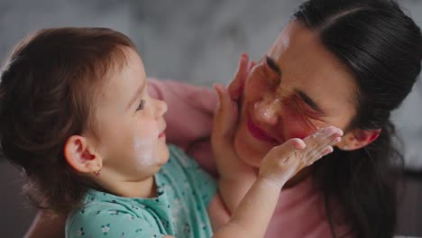 a joyful moment of connection: a parent and child playfully engaging in a lighthearted activity with creamy substance on their faces