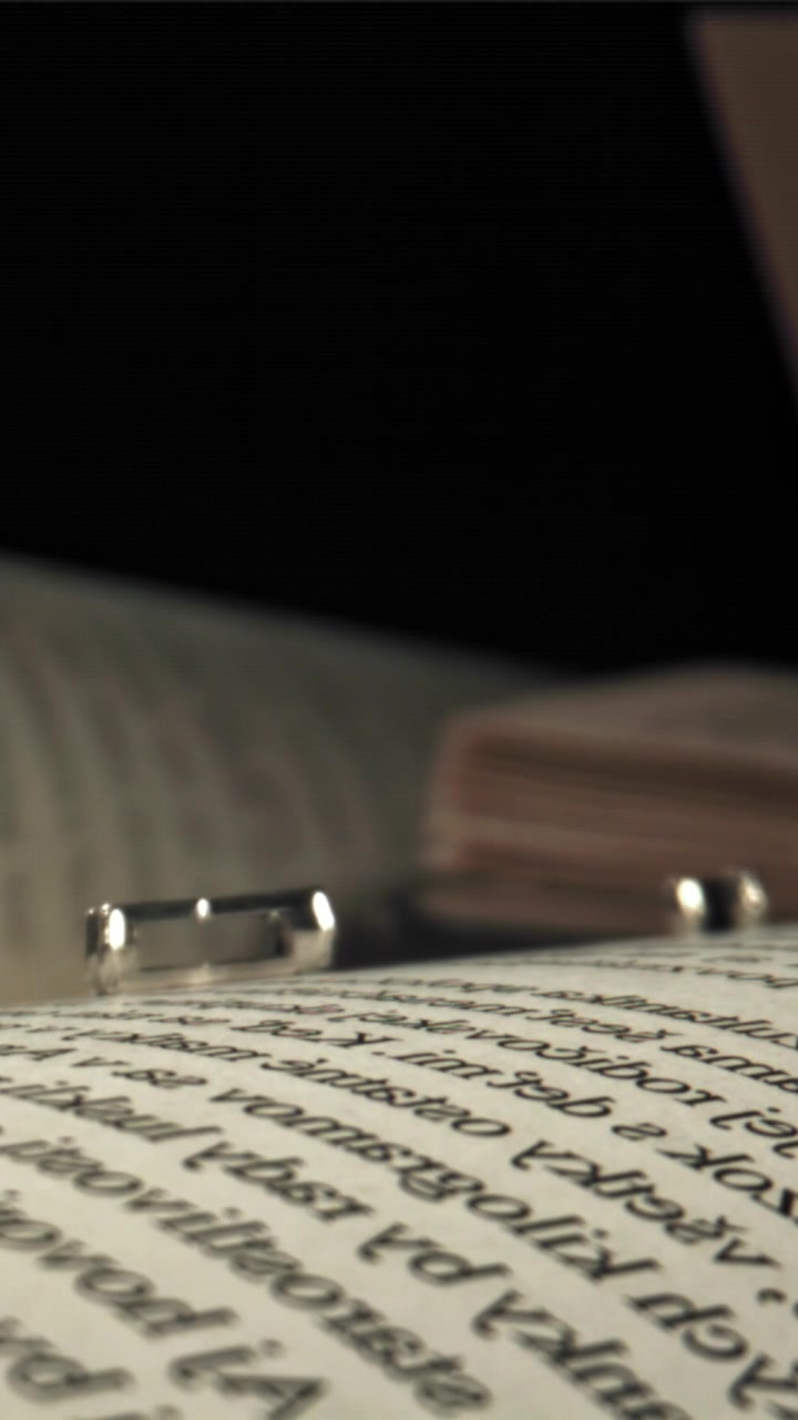 Metal Letters of the Alphabet Falling onto a Book Page