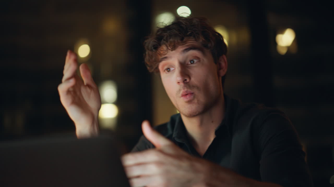 Closeup freelancer video calling by laptop discussing work task at night office