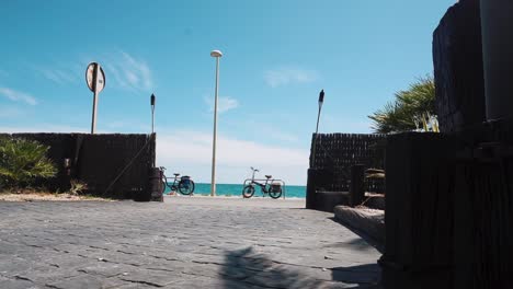 tourists walking in front of mar chica restaurant with a view of seaside road and ocean during summer in benicarlo, spain. - timelapse