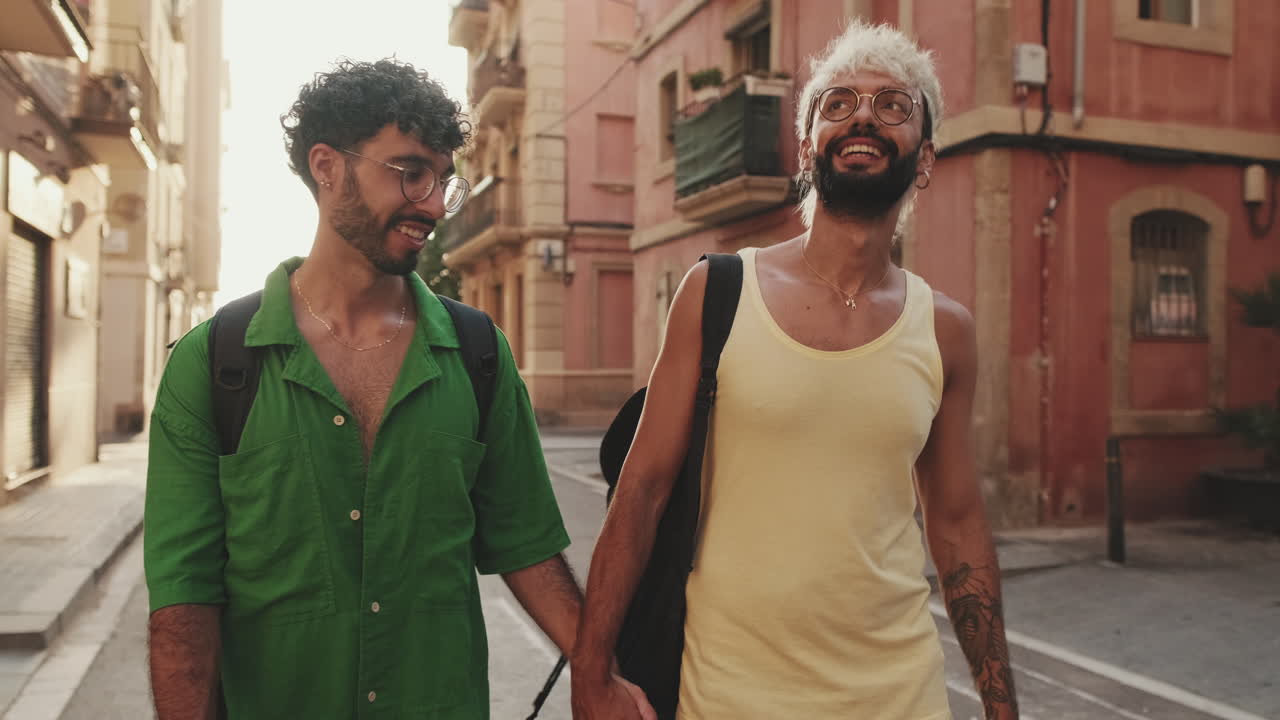 Coppia gay che cammina mano nella mano per una strada cittadina