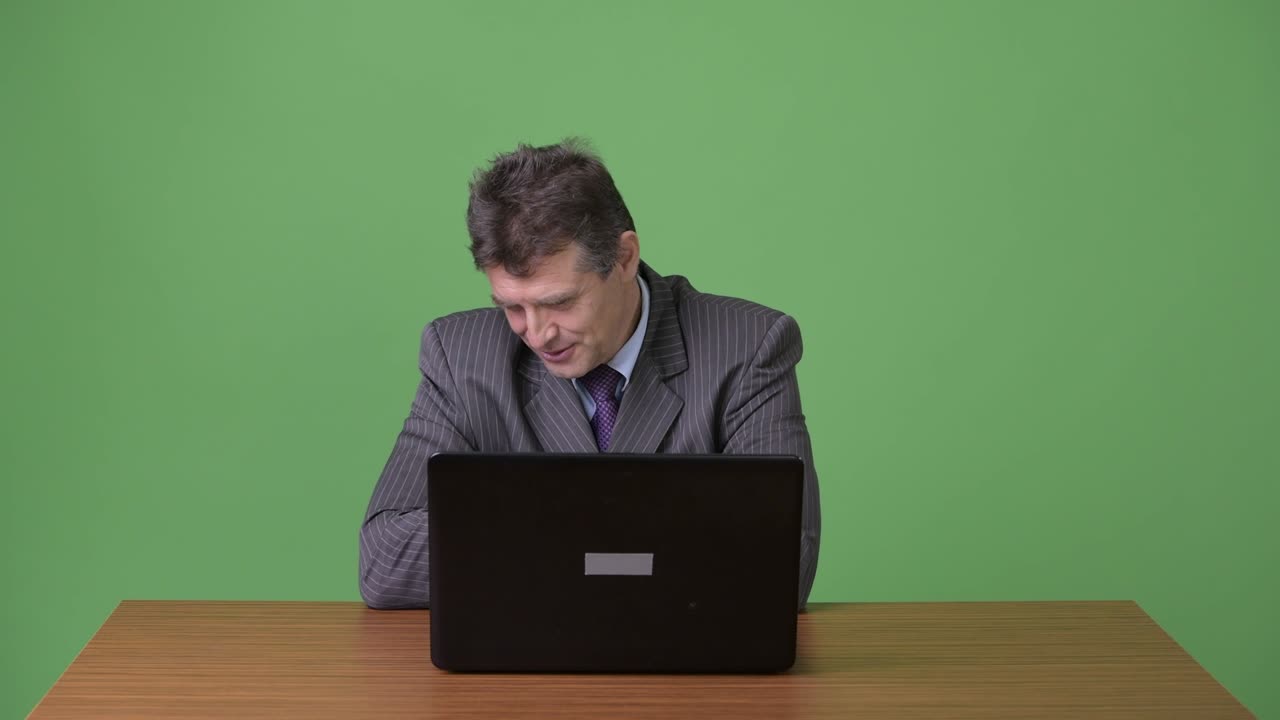 hombre de negocios maduro y guapo contra un fondo verde