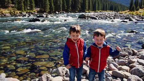 two happy boys playing by a river
