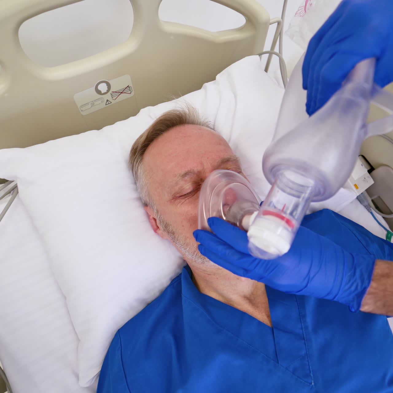 Face of a patient in bed and doctor giving resuscitation indoors. Emergency in the hospital. Doctor tries to save patient's life. Close-up.