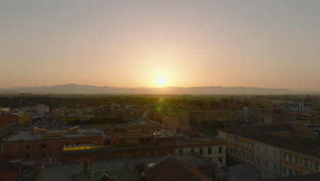 Fly-above-city-at-romantic-sunrise.-Backwards-reveal-of-tower-and-church.-Mountain-ridge-in-distance.-Rome,-Italy