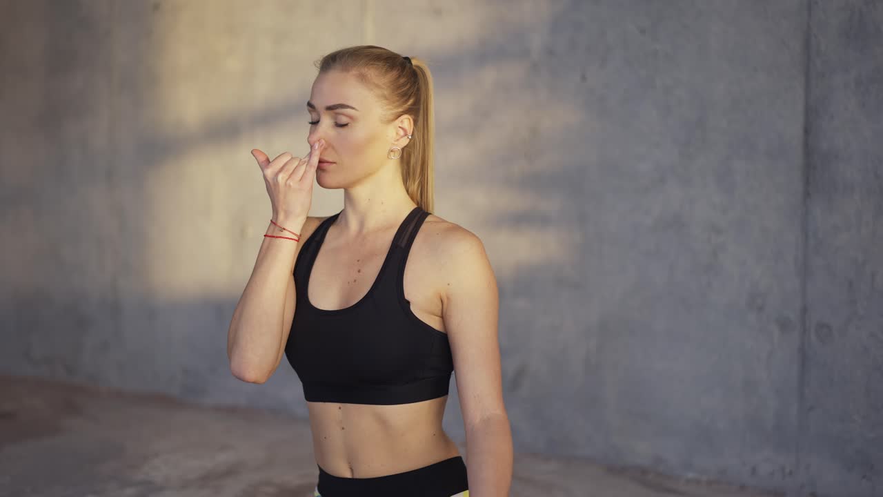 la chica cierra las fosas nasales haciendo prácticas de respiración en el estudio