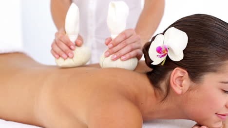 woman enjoying a herbal compress massage