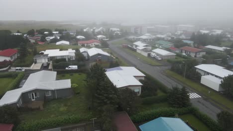 Hover-over-Höfn's-quaint-neighborhood-shrouded-in-fog-with-our-drone's-eye-view,-revealing-the-town's-serene-atmosphere-in-high-definition-4K