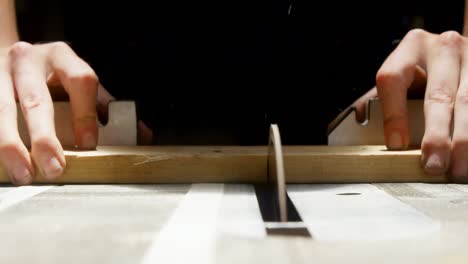 female welder using table saw on a wooden plank in workshop 4k