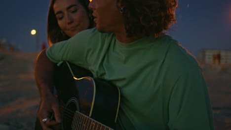 laughing couple enjoying guitar evening beach closeup. young woman bonding man