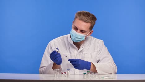 un científico farmacéutico llena una jeringa con la vacuna contra el coronavirus covid-19 estudio de una cura para un brote de enfermedad por el virus de la corona pantalla azul clave de croma cerrar la cámara lenta