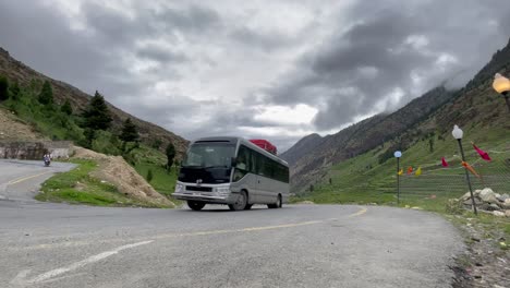 a coach travels through the winding mountain road in babusar pass, connecting khyber pakhtunkhwa and gilgit-baltistan, showcasing stunning landscapes and adventure travel vibes.