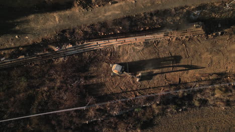 aerial top down view of an excavator landscaping in sunset