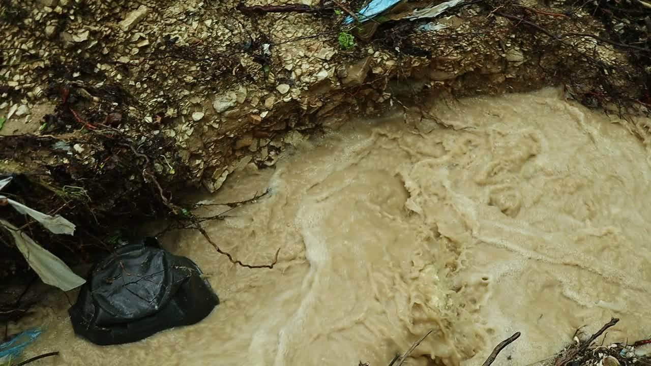 acque sporche scorrono in un ruscello inquinato da rifiuti umani